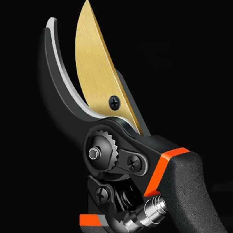 Close-up view of the open blades of the garden pruning shears. The top blade is a gold color, contrasting with the black lower blade. The shears are slightly open, highlighting the sharp cutting edges and the sturdy construction